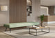 The Omni Collaborative Soft Seating Bench is a modern office furniture piece. This long dusty teal upholstered bench sits centrally on a light rug in a contemporary office reception area. It suits flexible working, informal collaboration and waiting areas in open lounges and breakout spaces. The bench helps create a productive workplace.