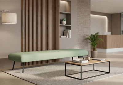 The Omni Collaborative Soft Seating Bench is a modern office furniture piece. This long dusty teal upholstered bench sits centrally on a light rug in a contemporary office reception area. It suits flexible working, informal collaboration and waiting areas in open lounges and breakout spaces. The bench helps create a productive workplace.