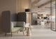 An Omni High-Back Acoustic Chair, a key piece of acoustic furniture designed to introduce comfort, privacy and acoustic balance. This acoustic chair is prominently placed in a modern open-plan office environment. A small side table sits beside the chair, creating an inviting private workspace or touchdown point. This modern office furniture solution supports flexible working styles and enhances the atmosphere of contemporary shared spaces by offering a calm retreat.